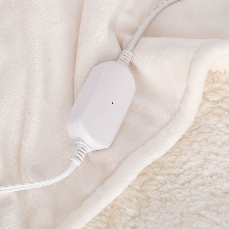 Close-up of the white power cord resting on the soft plush material of the throw.