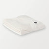 Folded cream heated wearable throw with visible power button.