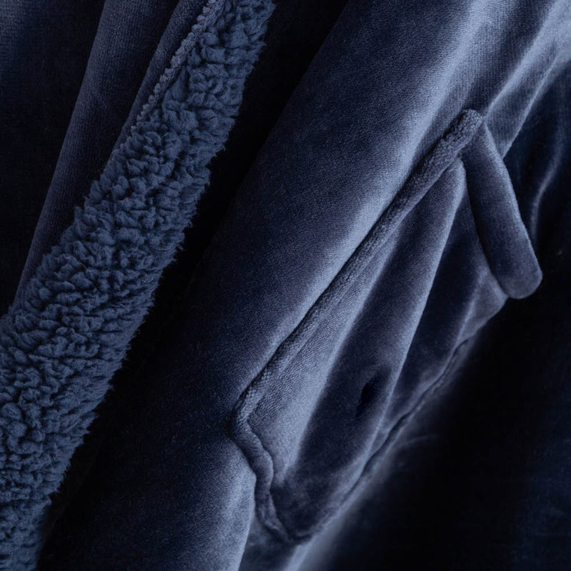 Detailed view of the dark plush interior of the navy heated wearable throw.