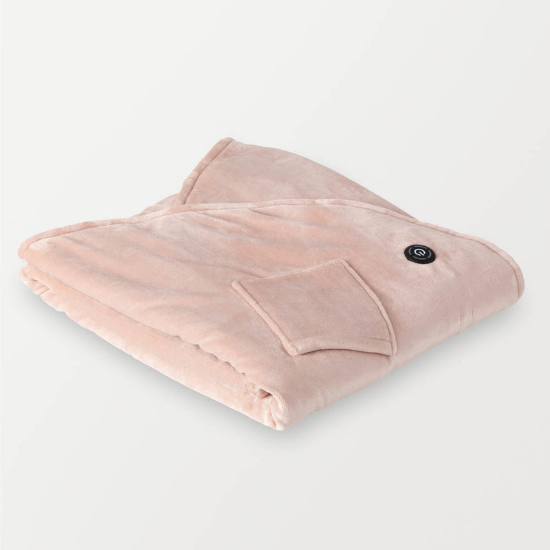 Folded soft pink heated wearable throw with the power button visible on the surface.