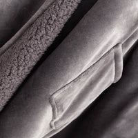 Close-up of the plush fabric edge of the gray heated wearable throw.