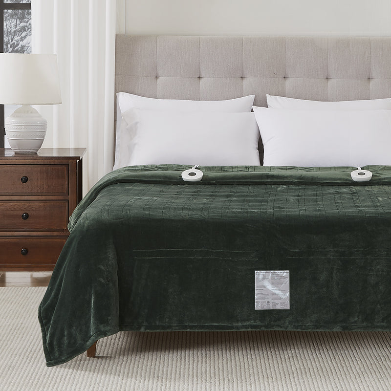 A neatly made bed with a gray upholstered headboard and a green heated blanket.