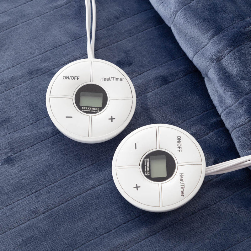 Close-up of two round controllers resting on a blue heated blanket.