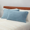 Blue microfleece pillowcases displayed on a bed.