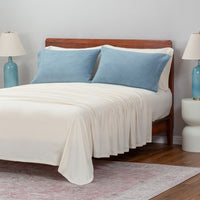 Blue pillowcases displayed on pillows on a bed in a bedroom setting.