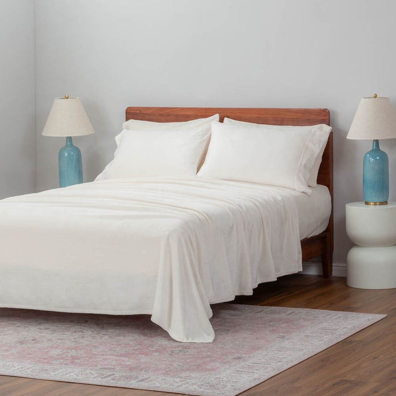 White pillowcases dressed on pillows displayed on a bed in a bedroom setting.