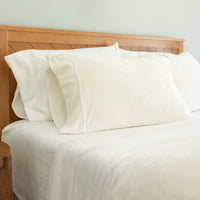 Bed with white bedding and wooden headboard