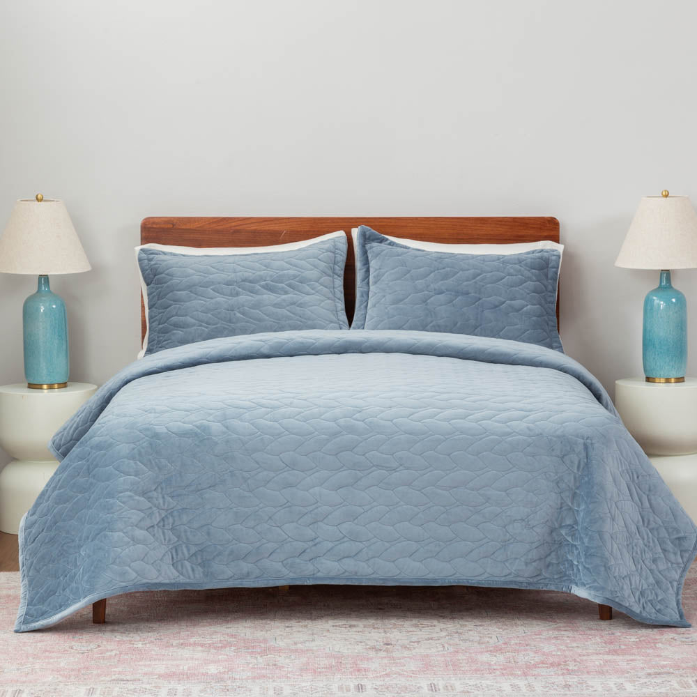 A bed styled with the Polar Blue VelvetLoft® Quilt Set, paired with two pillow shams.