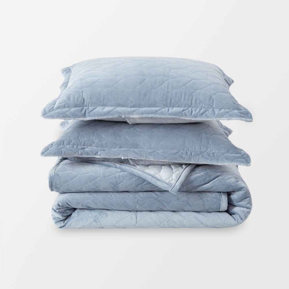 Polar Blue VelvetLoft® Quilt Set folded and stacked neatly with matching pillow shams.