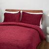 Red quilt set decorated on a bed.