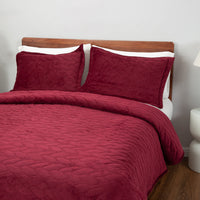 Red quilt set decorated on a bed.