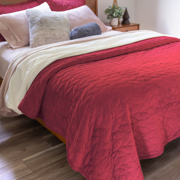 A bed styled with the Windsor Wine VelvetLoft® Quilt Set,  an assortment of pillows, our VelvetLoft sheet set and VelvetLoft blanket layered into an inviting lived in bed. 