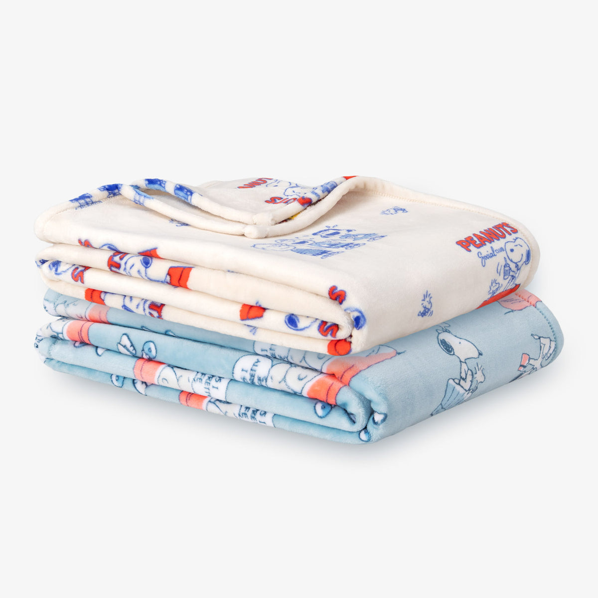 Printed Peanuts 75th Anniversary throws stacked neatly on a white surface.