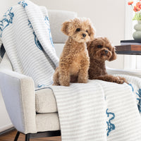 Two dogs sitting on a sofa with our Peanuts MellowSoft Throw.