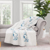 Peanuts striped MellowSoft Throw draped over a grey sofa in a living space.