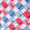 Close up of a blue and pink Peanuts 75th Anniversary packable outdoor blanket, showcasing the quilted texture.