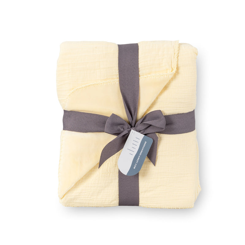 Yellow VelvetLoft Gauze Throw folded neatly on a white surface.