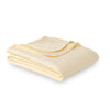Yellow VelvetLoft Gauze Throw folded neatly on a white surface.