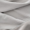 Close up of a grey VelvetLoft Gauze Throw.