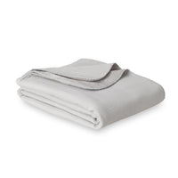 Grey VelvetLoft Gauze Throw folded neatly on a white surface.