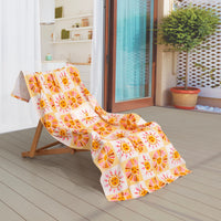 Vicky Yorke Summer Nostalgia beach draped neatly over a wooden lounge chair on a patio.