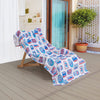 Krissy Mast beach towel draped over a wooden lounge chair on a patio.