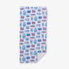 Close up of a Krissy Mast Sardine printed beach towel laid flat on a white surface.