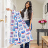 A women holding a sardine printed beach towel draped over her arms.