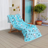 Blue Peanuts beach towel draped neatly on a wooden lounge chair on a patio.