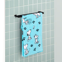 Blue Peanuts beach towel draped neatly over a towel hanger in a bathroom.
