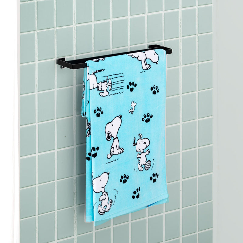 Blue Peanuts beach towel draped neatly over a towel hanger in a bathroom.