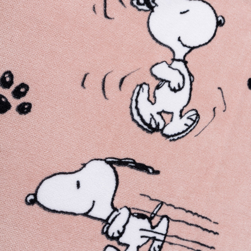 Close up of a pink Peanuts beach towel.