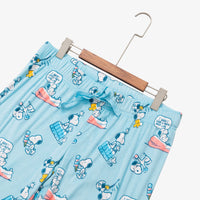 Peanuts 75th Anniversary printed lounge pants laid flat with a hanger on a white surface.