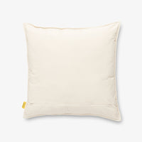 Back side of a Peanuts Social Club Pillow sitting on a white surface.