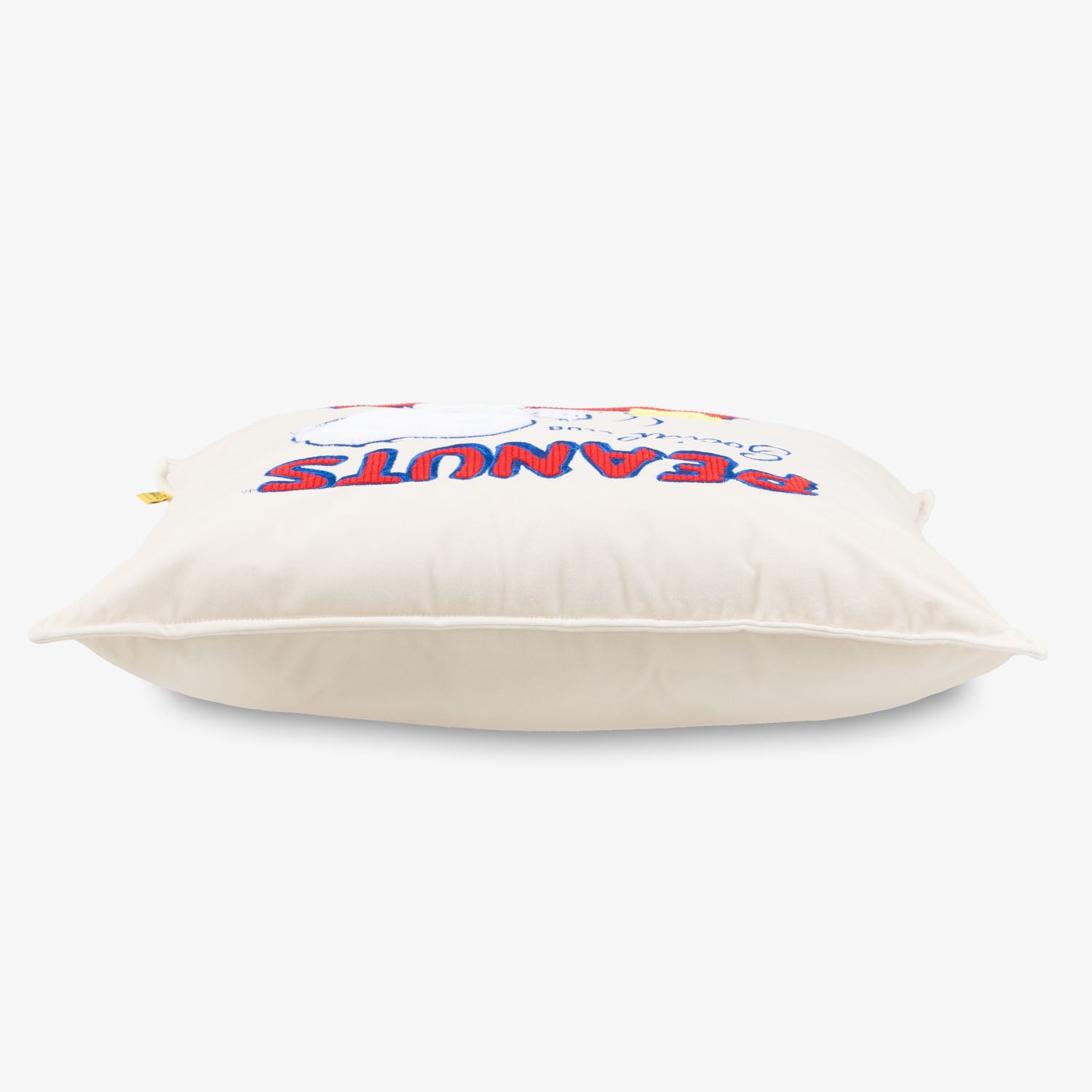 Peanuts Social Club Pillow sitting on a white surface.