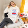 A woman sitting in a chair while wearing a peanuts lounge hoodie.