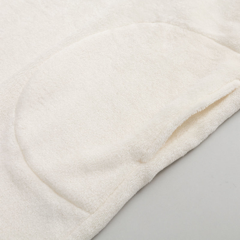 Close up of the pocket of our Peanuts social club embroidered lounge hoodie on a white surface.