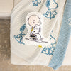 Charlie Brown & Snoopy embroidered pillow laying on our Peanuts MellowSoft Throw.