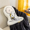 Charlie Brown & Snoopy embroidered pillow laying on a plush black throw on a chair.