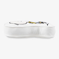 Side profile of a Charlie Brown & Snoopy embroidered pillow on a white surface.