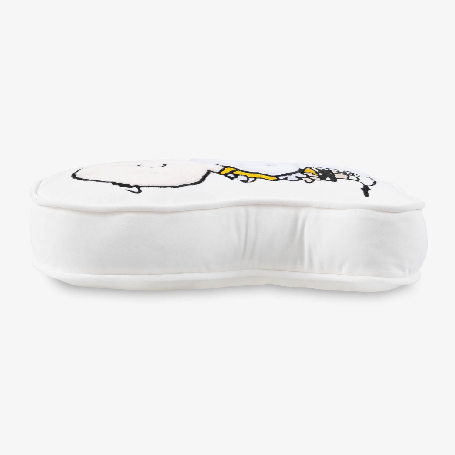 Side profile of a Charlie Brown & Snoopy embroidered pillow on a white surface.