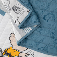 Close up of a blue Peanuts patchwork quilt set.