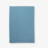 Reverse side of a blue peanuts patchwork quilt set laid flat on a white surface.