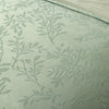 Textured fabric with leaf pattern on a light green background