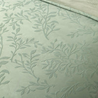 Textured fabric with leaf pattern on a light green background