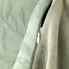 Close-up of a green textured fabric with a zipper detail