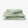 Set of green floral-patterned bedding on a white background