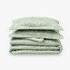 Stack of green floral-patterned bedding on a white background