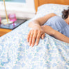 Person lying in bed with floral bedding