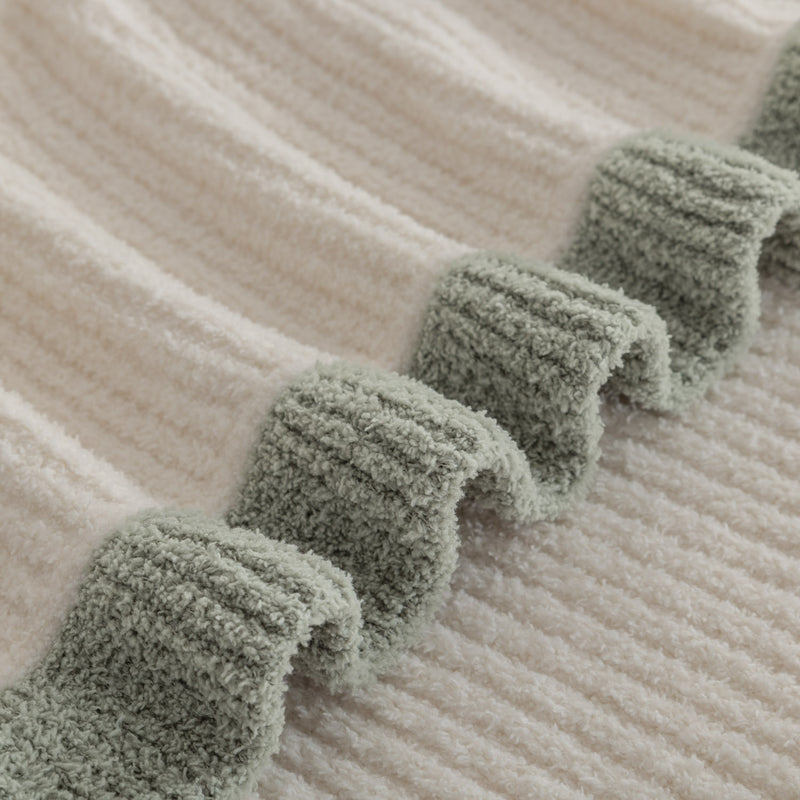 Close-up of a textured fabric with green trim on a beige background